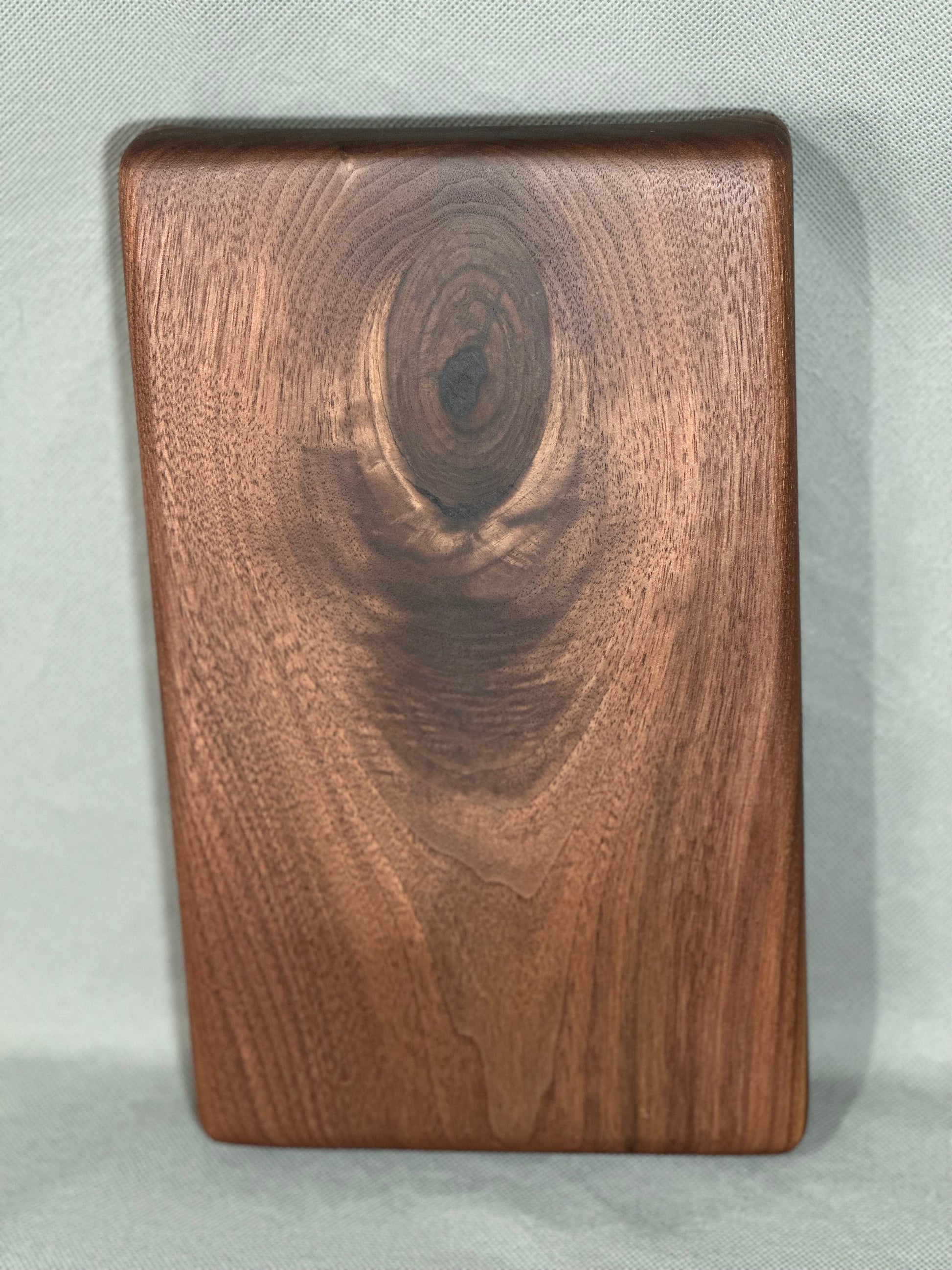 The Knot showcases the natural aesthetic of walnut in this serving board. Whether you're indulging in a cheese plate, showcasing snacks at a social gathering, or safeguarding your surface from heat damage—this board makes an elegant show piece or a perfect gift!