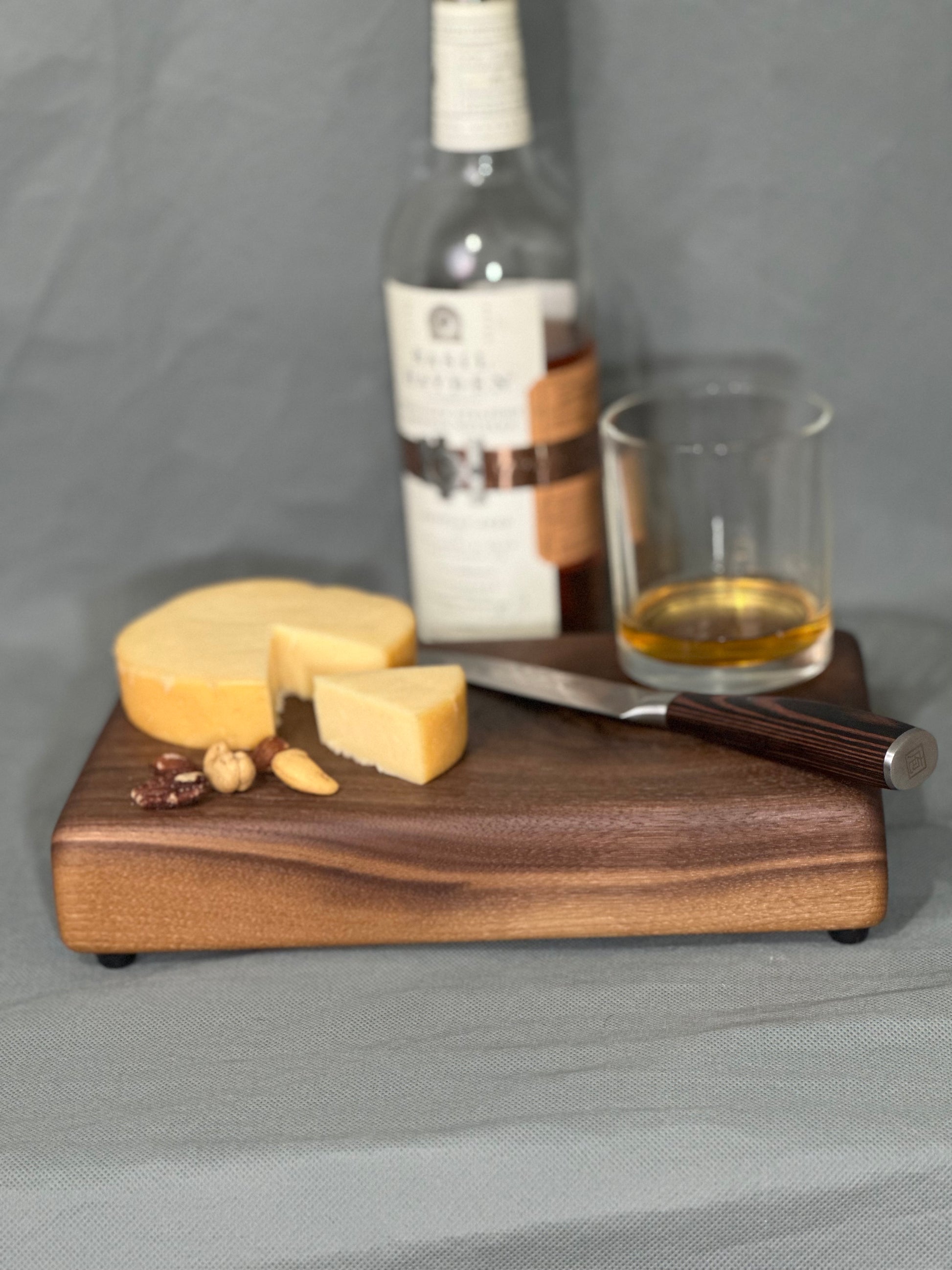 The Knot showcases the natural aesthetic of walnut in this serving board. Whether you're indulging in a cheese plate, showcasing snacks at a social gathering, or safeguarding your surface from heat damage—this board makes an elegant show piece or a perfect gift!